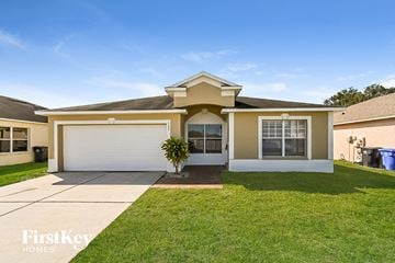 Brandon house for rent - a beige house with a white garage door and a lawn