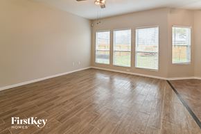 Spring house for rent - A room with wooden flooring and three windows.