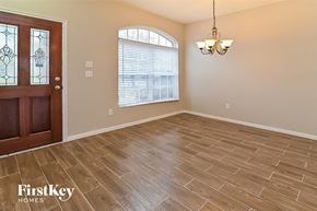 Spring house for rent - A room with a wooden floor and a chandelier hanging from the ceiling.