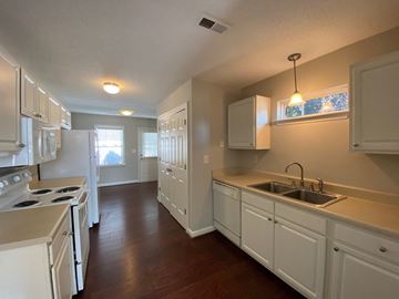 Youngsville apartment for rent - A kitchen with white cabinets and a stove top oven.