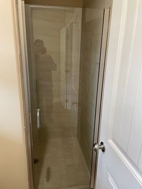 Trinity house for rent - A person is taking a picture of a bathroom with a glass door.