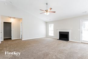 Charlotte house for rent - a living room with a fireplace and a ceiling fan
