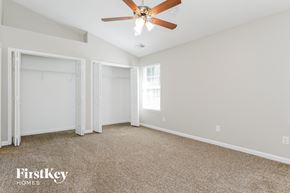 Charlotte house for rent - a bedroom with white walls and carpet and a ceiling fan