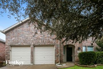 Burleson house for rent - a brick house with two white garage doors