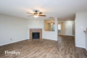 Burleson house for rent - a living room with a fireplace and a ceiling fan