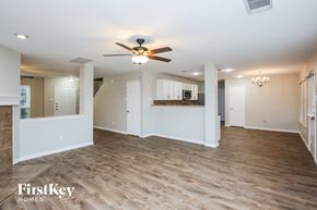 Burleson house for rent - an empty living room with a ceiling fan and a kitchen