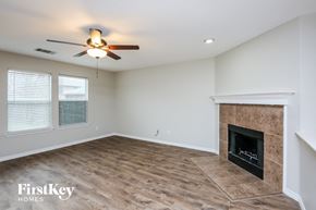Burleson house for rent - a living room with a fireplace and a ceiling fan