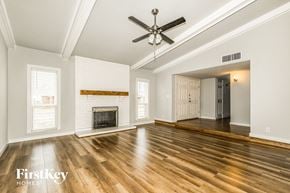 Carrollton house for rent - an empty living room with a fireplace and a ceiling fan