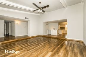 Carrollton house for rent - an empty living room with hardwood floors and a ceiling fan