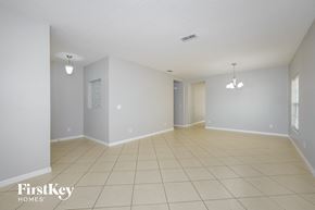 Kissimmee house for rent - a spacious living room with tiled floors and white walls