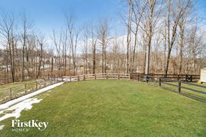 Amelia house for rent - a large backyard with trees and a fence