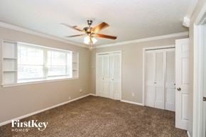 Houston house for rent - a bedroom with a ceiling fan and a closet