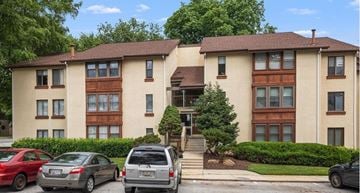 Columbia house for rent - A large apartment building with a car parked in front.