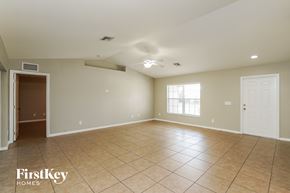 Lehigh Acres house for rent - A spacious room with tile flooring and a ceiling fan.