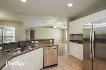 Lehigh Acres house for rent - A kitchen with a stainless steel refrigerator and a dishwasher.
