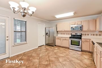 Houston house for rent - A kitchen with a tile floor and a stove top oven.
