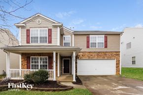 Charlotte house for rent - a beige house with red shutters and a white garage door
