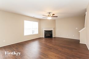 Charlotte house for rent - an empty living room with wood floors and a fireplace
