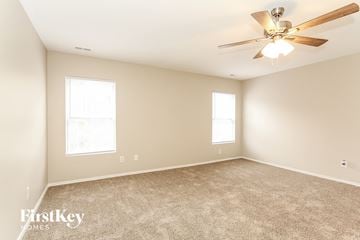 Charlotte house for rent - a living room with carpet and a ceiling fan