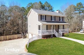Alabaster house for rent - a small white house with a porch and a lawn and a driveway
