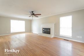 Alabaster house for rent - a living room with wood floors and a fireplace and a ceiling fan