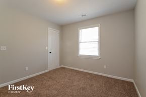 Alabaster house for rent - a bedroom with carpet and a door and a window