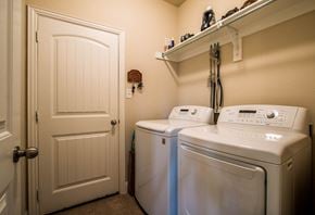 Aubrey house for rent - A white door is open to a laundry room with a washer and dryer.