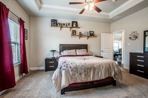 Aubrey house for rent - A bedroom with a large bed and a ceiling fan.