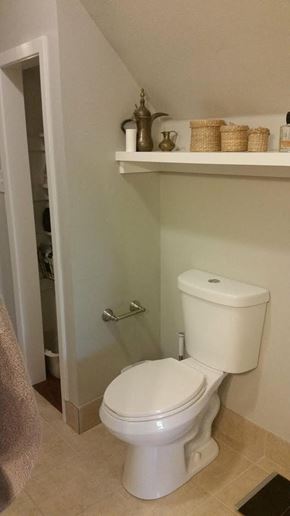 Denton house for rent - A white toilet in a bathroom with a white shelf above it.