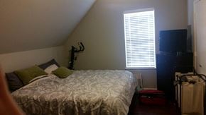 Denton house for rent - A bedroom with a bed, a TV, and a window with blinds.