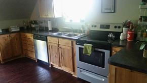 Denton house for rent - A kitchen with wooden cabinets and a black countertop.