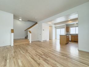 Draper apartment for rent - the living room and kitchen of an empty home with wood flooring