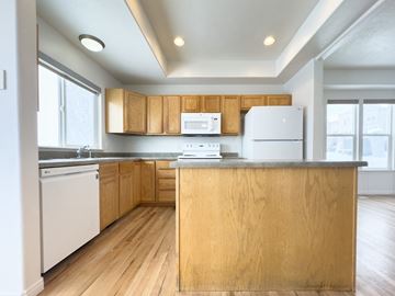Draper apartment for rent - the preserve at ballantyne commons apartment kitchen with white appliances and wood cabinets
