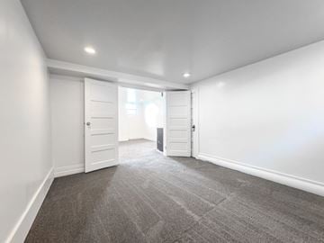 Provo apartment for rent - a living room with white walls and carpet and a door to a closet