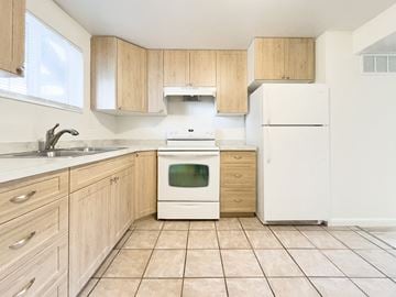 Springville apartment for rent - a kitchen with white appliances and wooden cabinets