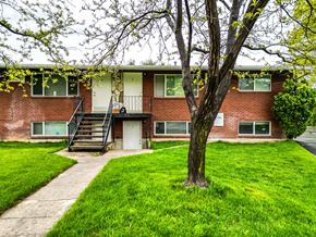 Springville apartment for rent - front view of a red brick building with a tree in the yard