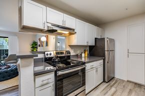 Hayward apartment for rent - Hayward, CA, Apartments Near Oakland - The Dutton Apartments - Modern Kitchen With White Cabinets, Gray Counters, and Stainless Steel Appliances.