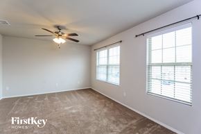 Fort Worth house for rent - A spacious room with a ceiling fan and two windows with blinds.
