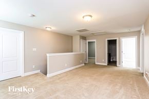 Mcleansville house for rent - A spacious empty room with a carpeted floor and white walls.