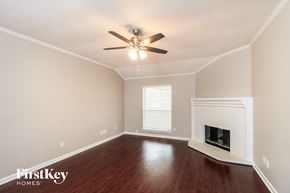 Arlington house for rent - A room with a fireplace and a ceiling fan.