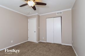 Monroe house for rent - a bedroom with a ceiling fan and two closet doors