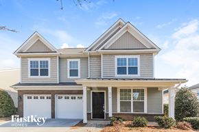 Huntersville house for rent - a beige house with white garage doors
