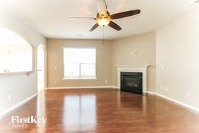 Huntersville house for rent - an empty living room with a ceiling fan and a fireplace