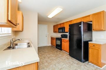 Charlotte house for rent - a kitchen with black appliances and wooden cabinets