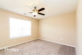 Charlotte house for rent - a bedroom with a ceiling fan and a window