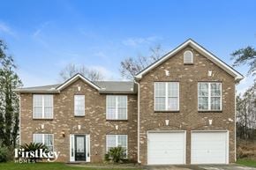 Lithonia house for rent - a brick house with white garage doors