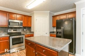 Lithonia house for rent - a kitchen with stainless steel appliances and granite counter tops