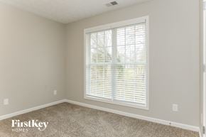 Lithonia house for rent - the second bedroom has a large window and beige carpet