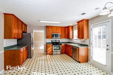 Loganville house for rent - a kitchen with wooden cabinets and a stove and a refrigerator
