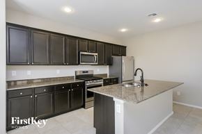 Mesa house for rent - a kitchen with granite counter tops and black cabinets and stainless steel appliances